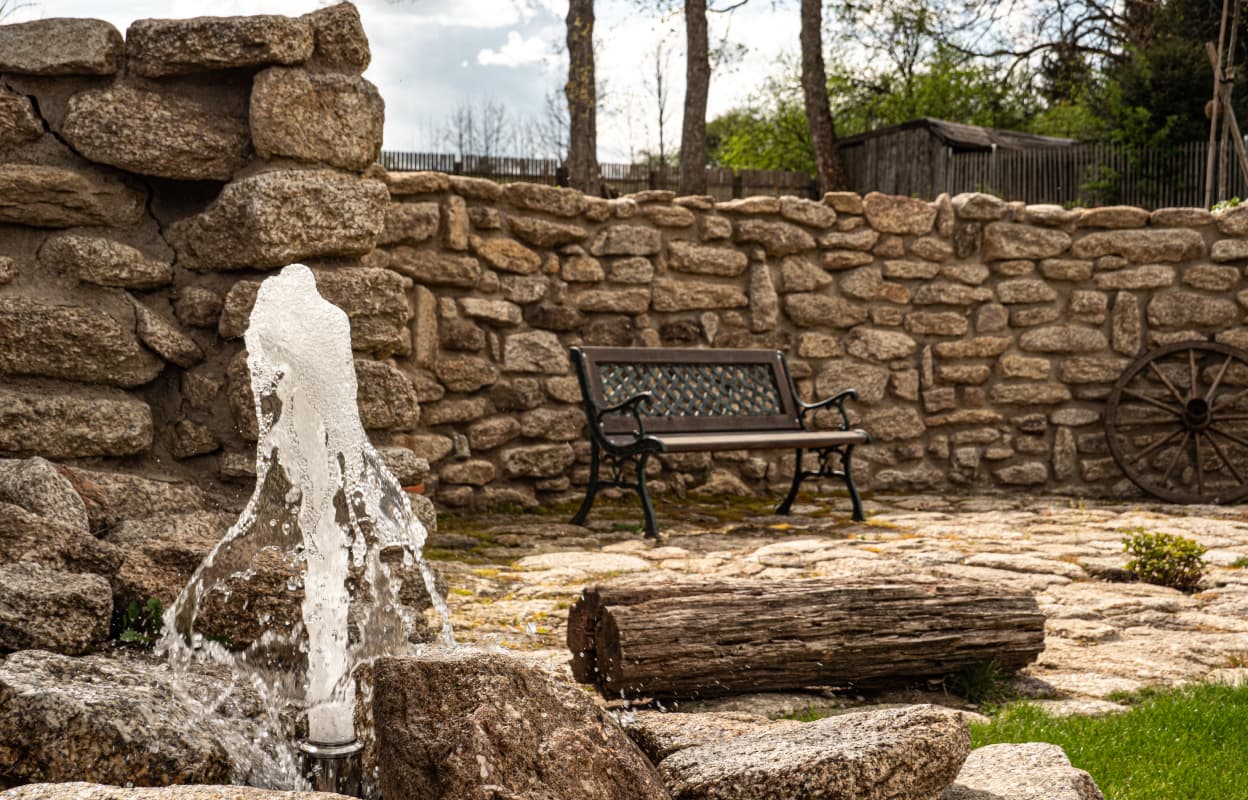 malý vodní prvek s přepadem vody v okrasné zahradě u domu