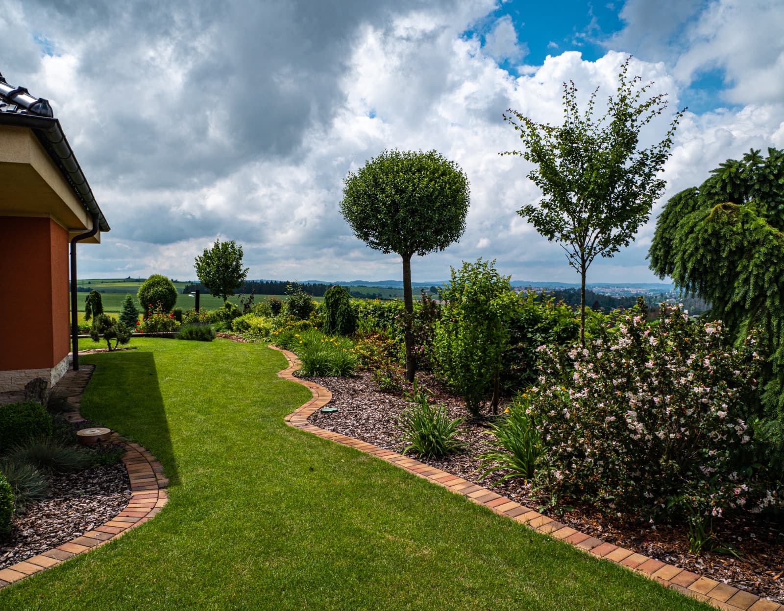 Přírodní zahrada bez hranic s hustým trávníkem a trvalkovou výsadbou